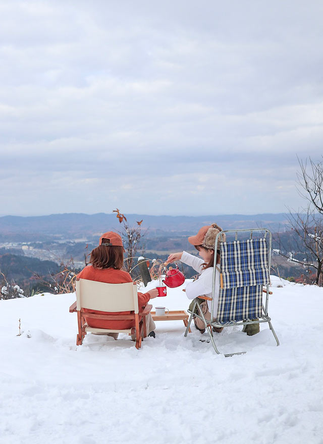 雪山でローチェアに座りながらお茶を飲む