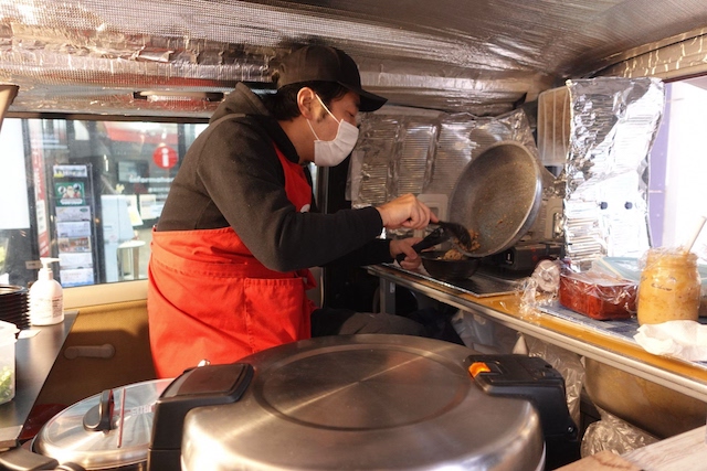 キッチンカー内で調理をする齋藤さん。提供前には必ず仕上げの過熱をする