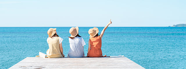 佐渡島佐和田の海水浴場にある「あやめの桟橋」に女性３人が座っている