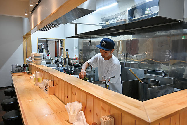 カウンター席の前で調理する〈Tsubame Ramen Yuki〉オーナー