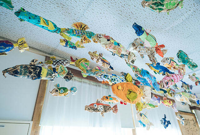 ワークショップでつくられたたくさんの魚が天井から吊るされている