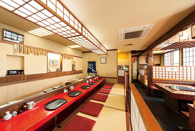 カウンター席とテーブル席が並ぶ〈天ぷら 若杉〉の店内