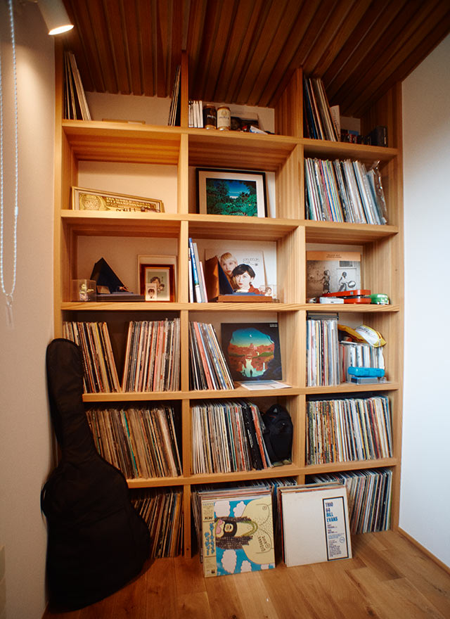 壁の棚にたくさんのレコードが並ぶ駒形さんの仕事部屋