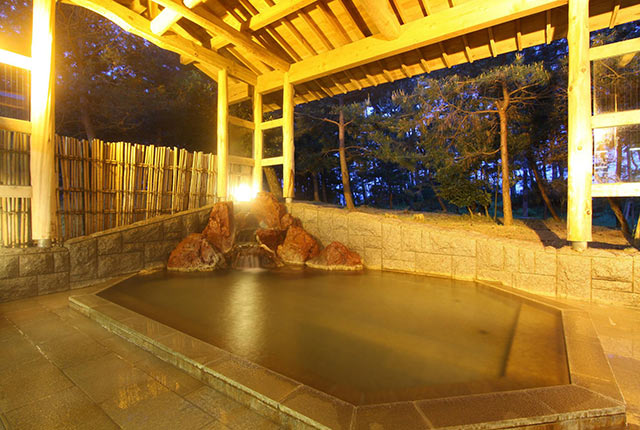 〈国際観光ホテル 八幡館〉の松林に囲まれた露天風呂