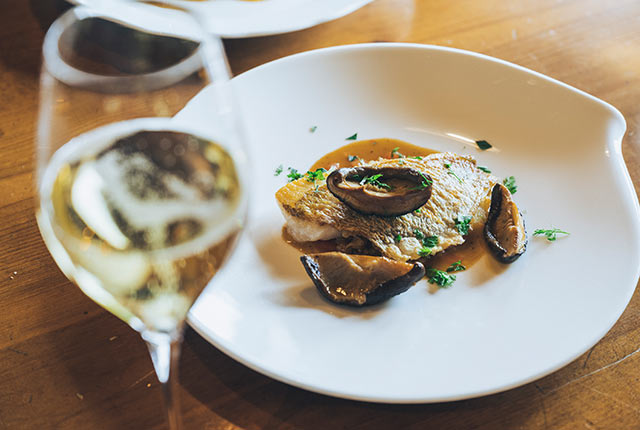 〈レストラン カーブドッチ〉で提供されるフレンチの魚料理とシャンパン