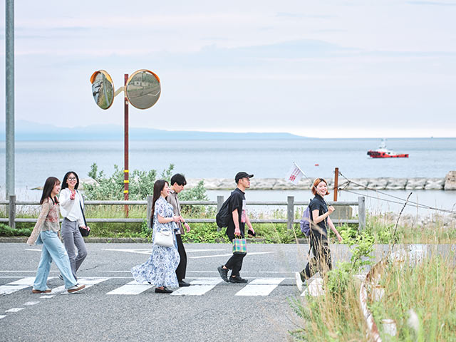 海沿いを歩くツアー参加者たち