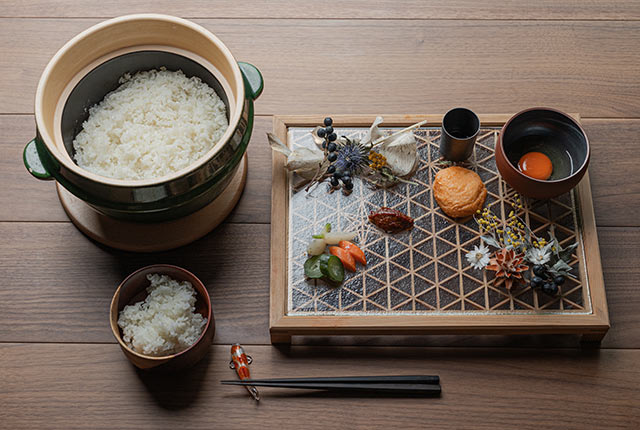 土鍋ご飯と、折敷皿に並んだ卵や漬物などのおかず