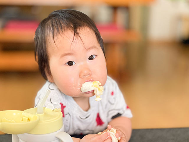 おやつを頬張る赤ちゃん