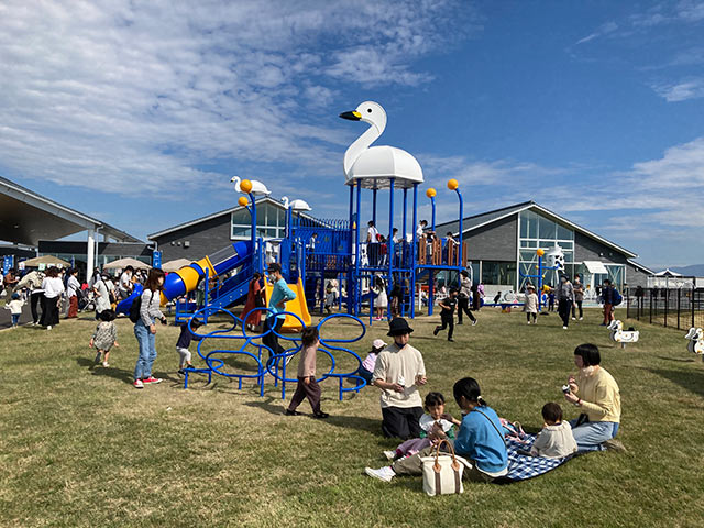 白鳥がモチーフの遊具でたくさんの親子が遊んでいる