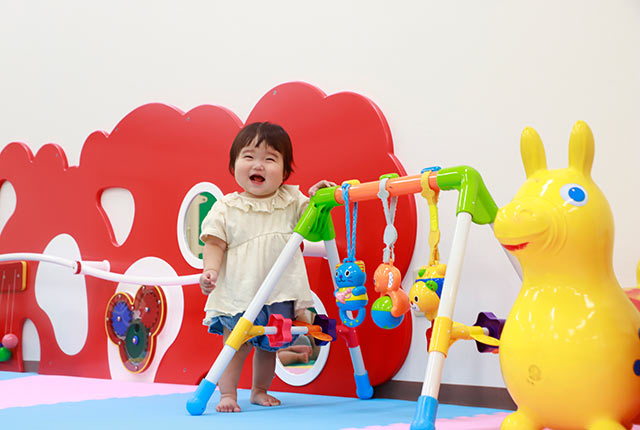 乳幼児エリアでカメラに笑顔を向けるこども
