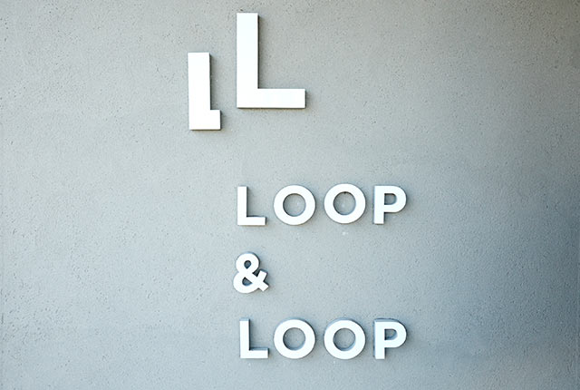 壁に設置された〈LOOP & LOOP〉のロゴ