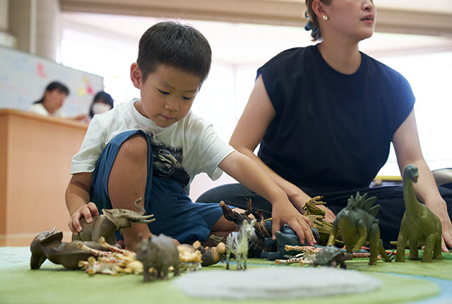 恐竜のソフト人形で遊ぶ男の子