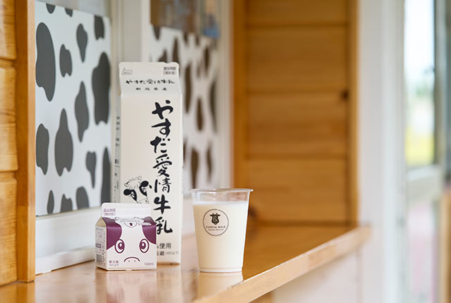 パック入りの〈やすだ愛情牛乳〉とカップに注いだ牛乳