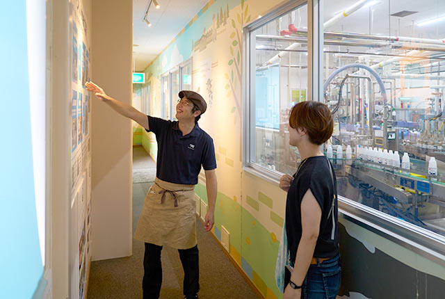 工場内の展示パネルを使い説明してくれている川上耕平さん