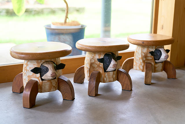 牛の顔が彫られた木製スツール