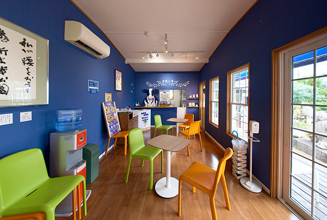 紺色の壁に、山吹色や橙色のスツールが映える〈洋食工房〉店内