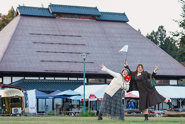 道の駅〈良寛の里 わしま〉の前でポーズを撮るふたり