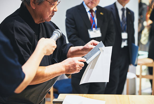 研ぎ終わった包丁で和紙を切っている