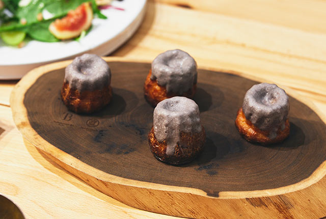 鉄パウダーを混ぜ込んだカヌレが木皿に並ぶ