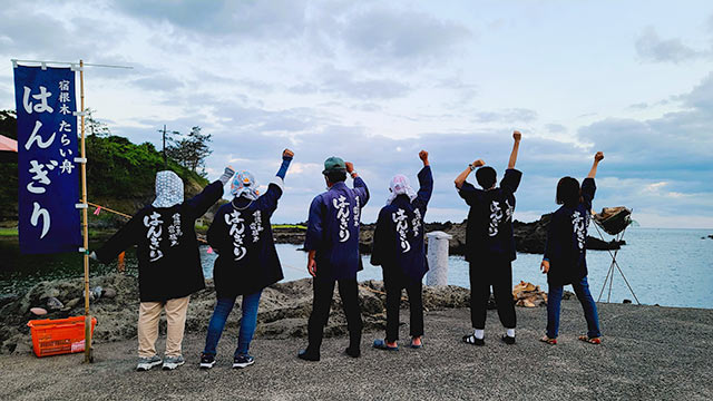 「はんぎり」と背中に書かれた法被を着た〈宿根木のたらい舟〉６人の後ろ姿