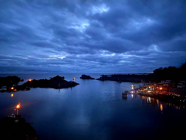 岩場にかがり火が焚かれたナイトツアーの様子を上空から