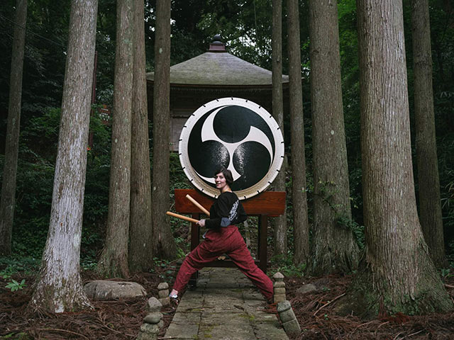 大きな和太鼓の前に立ちカメラに振り向いたナタリーさん