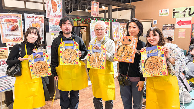 完成しパッケージングされたせんべいをそれぞれ手にしているツアー参加者たち