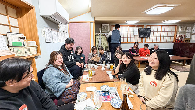 〈喜ぐち〉のテーブル席に座るツアー参加者たち