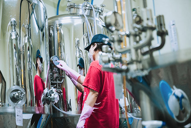 クラフトビールの醸造タンクの計器を確認する佐藤さん