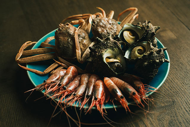 佐渡で獲れたカニ、さざえ、南蛮エビが皿にのっている