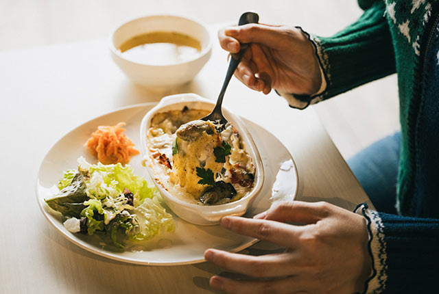 佐渡加茂湖産牡蠣ドリアをスプーンですくう