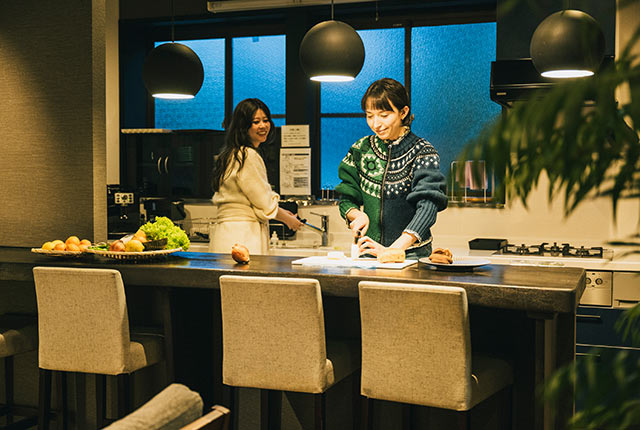 カウンターに立ち食材を切るアリスさん