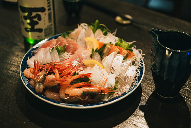 南蛮エビ、ヒラマサなどの刺し盛りと純米酒〈至〉のボトル