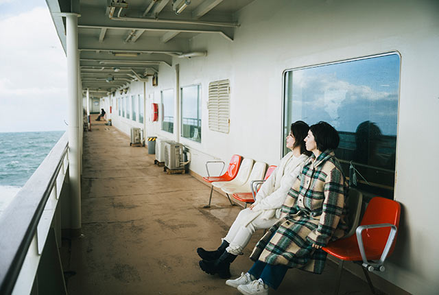 新潟港へと向かうフェリーのデッキに座るアリスさん