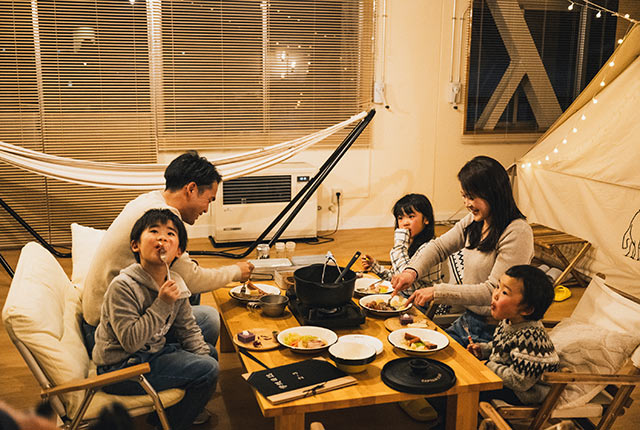 ローテーブルで鍋料理を味わうファミリー