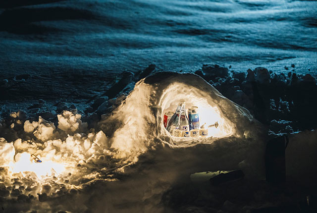 ライトアップされた小さなかまくらの中で飲み物が冷やされている