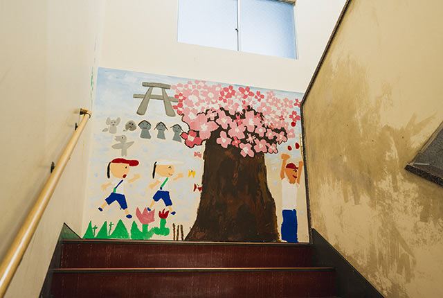 踊り場の大きな壁に、桜や児童たちの絵が描かれている