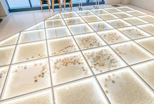 ガラス張りの床下に新潟県の形をかたどったアート作品が展示されている