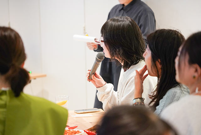 マイクでコメント中のイベント参加者