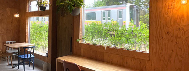 〈banbi latteとcoffee〉店内窓のすぐ前を電車が通り過ぎている様子