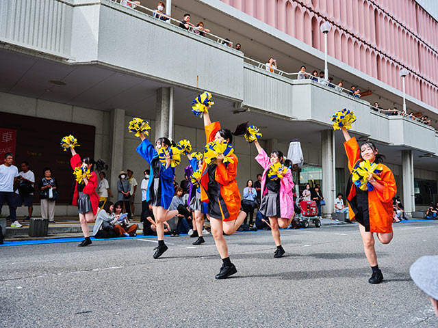 カラフルな法被の衣装でチアダンスを披露する〈万代高校ダンス部〉